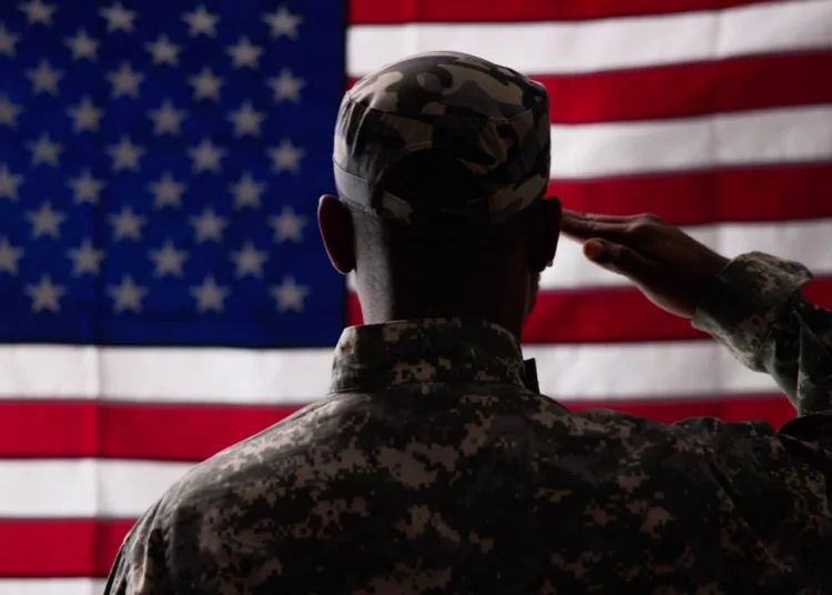 Rear View Of Military Man Saluting Us Flag