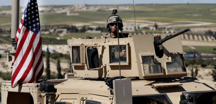A U.S. soldier sits in an armored vehicle on a road leading to the tense front line with Turkish-backed fighters, in Manbij, north Syria, Wednesday, April 4, 2018. President Donald Trump expects to decide "very quickly" whether to remove U.S. troops from war-torn Syria, saying their primary mission was to defeat the Islamic State group and "we've almost completed that task." (AP Photo/Hussein Malla)
