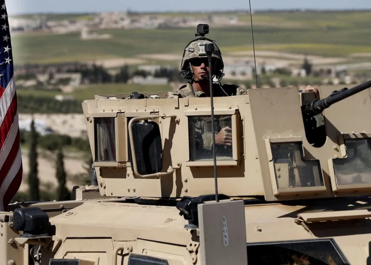 A U.S. soldier sits in an armored vehicle on a road leading to the tense front line with Turkish-backed fighters, in Manbij, north Syria, Wednesday, April 4, 2018. President Donald Trump expects to decide "very quickly" whether to remove U.S. troops from war-torn Syria, saying their primary mission was to defeat the Islamic State group and "we've almost completed that task." (AP Photo/Hussein Malla)