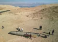 A drone view shows people stand around apparent remains of a ballistic missile lying in the desert, following an attack by Iran on Israel, near the southern city of Arad, Israel October 2, 2024. REUTERS/Amir Cohen
