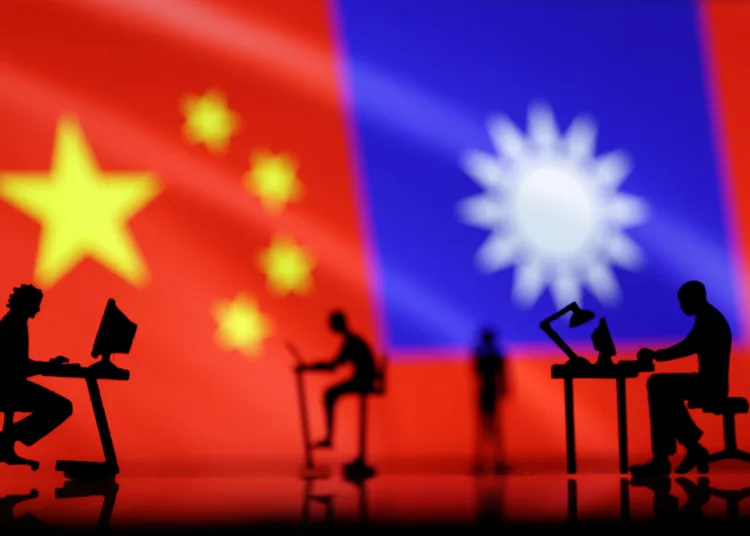 Small figurines with computers are seen in front of Chinese and Taiwanese flags in this illustration, August 6, 2022. REUTERS/Dado Ruvic/Illustration/ File Photo