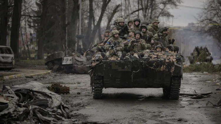 Ukrainian servicemen ride on a fighting vehicle outside Kyiv, Ukraine, Saturday, April 2, 2022. As Russian forces pull back from Ukraine's capital region, retreating troops are creating a "catastrophic" situation for civilians by leaving mines around homes, abandoned equipment and "even the bodies of those killed," President Volodymyr Zelenskyy warned Saturday. (AP Photo/Vadim Ghirda)