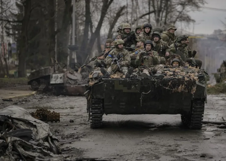 Ukrainian servicemen ride on a fighting vehicle outside Kyiv, Ukraine, Saturday, April 2, 2022. As Russian forces pull back from Ukraine's capital region, retreating troops are creating a "catastrophic" situation for civilians by leaving mines around homes, abandoned equipment and "even the bodies of those killed," President Volodymyr Zelenskyy warned Saturday. (AP Photo/Vadim Ghirda)