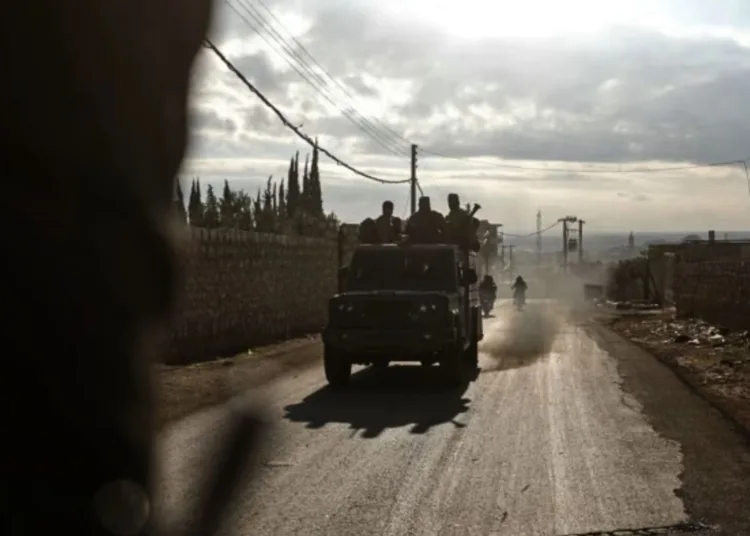 A truck carrying HTS fighters on a road near Atarib © Abdulaziz Ketaz/AFP/Getty Images