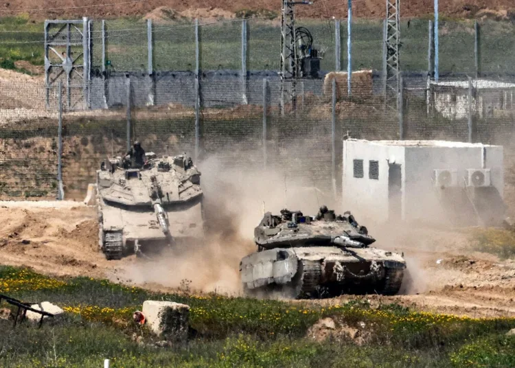 Israeli army Merkava main battle tanks move at a position in southern Israel along the border fence with the northern Gaza Strip on March 18, 2025. Israel on March 18 unleashed its most intense strikes on the Gaza Strip since a January ceasefire, with rescuers reporting 220 people killed, and Hamas accusing Benjamin Netanyahu of deciding to "resume war" after a deadlock on extending the truce.