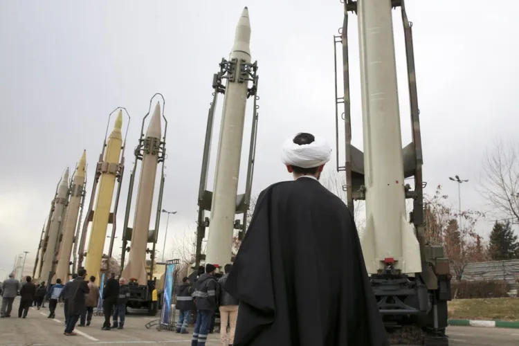 An Iranian cleric looks at domestically built surface-to-surface missiles at a military show marking  the 40th anniversary of Iran's Islamic Revolution that toppled the U.S.-backed shah, at Imam Khomeini Grand Mosque, in Tehran, Iran, Sunday, Feb. 3, 2019.  Since 1992, Iran has developed a self-sufficient military weapons program, producing mortars to missiles. (AP Photo/Vahid Salemi)
