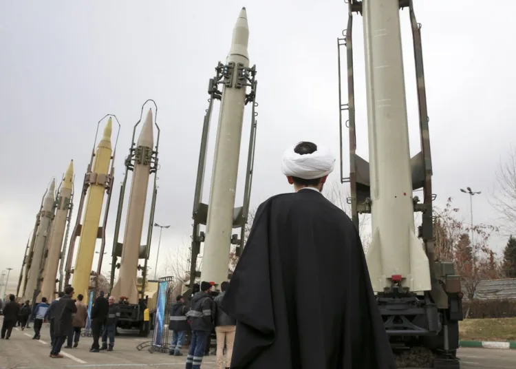 An Iranian cleric looks at domestically built surface-to-surface missiles at a military show marking the 40th anniversary of Iran's Islamic Revolution that toppled the U.S.-backed shah, at Imam Khomeini Grand Mosque, in Tehran, Iran, Sunday, Feb. 3, 2019. Since 1992, Iran has developed a self-sufficient military weapons program, producing mortars to missiles. (AP Photo/Vahid Salemi)