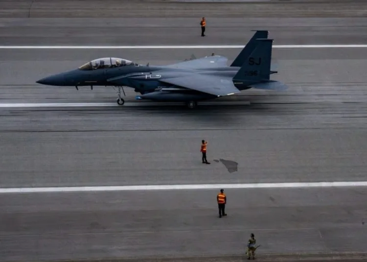 Aviadores de las Fuerzas Aéreas de EE.UU. vigilan un avión en una pista junto a un F-15E Strike Eagle.Foto de las Fuerzas Aéreas de EE.UU. por la Sargento Mayor Nadine Barclay