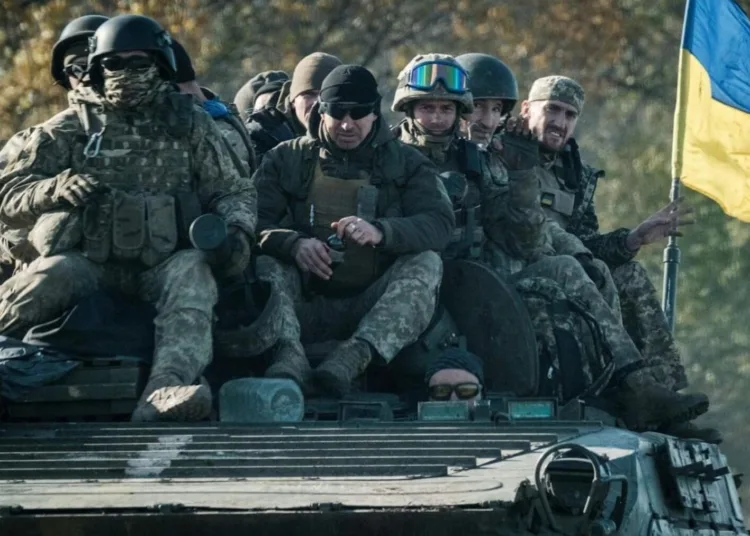 Ukrainian soldiers ride on an armoured vehicle in Novostepanivka, Kharkiv region, 19 September 2022 (Yasuyoshi Chiba/AFP via Getty Images)