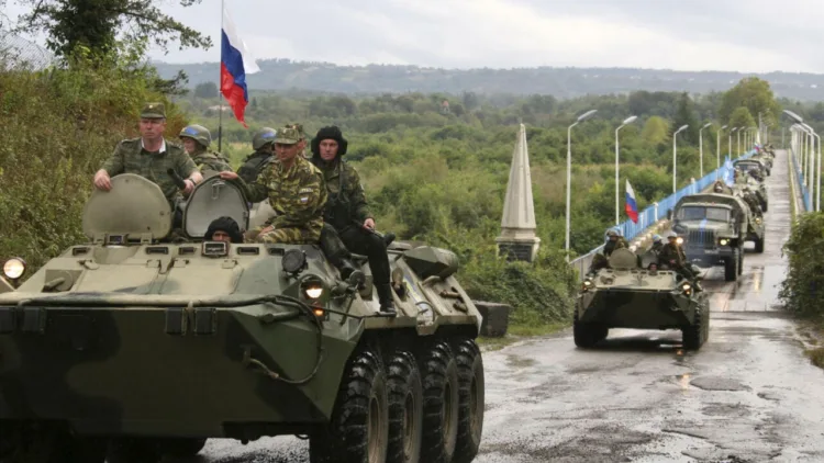 Russian soldiers sit atop armored vehicles as they cross a bridge over the Inguri River as Russian troops pull out from an area outside Georgia's breakaway province of Abkhazia, Wednesday, Oct. 8, 2008. Moscow must withdraw its troops from buffer zones surrounding the two regions by Friday under cease-fire agreements brokered by French President Nicolas Sarkozy in the wake of the August war. (AP Photo/Vladimir Popov)