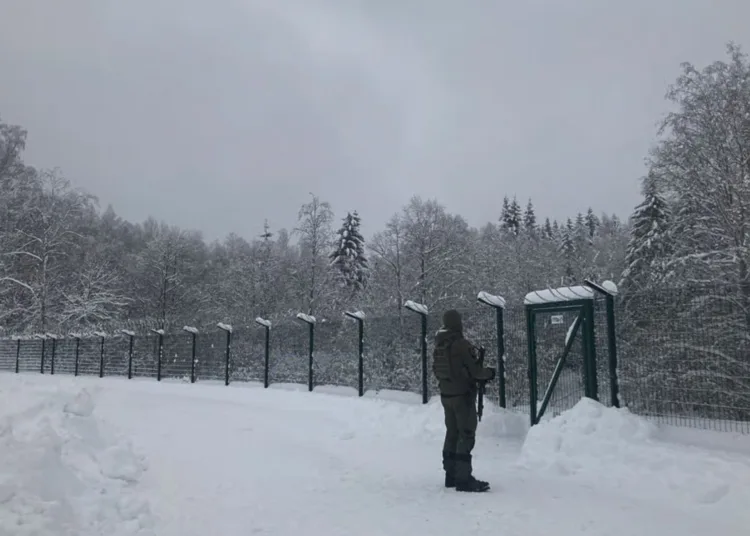 Un guardia fronterizo estonio observa el bosque ruso junto a una nueva valla estonia | Stuart Lau para POLITICO