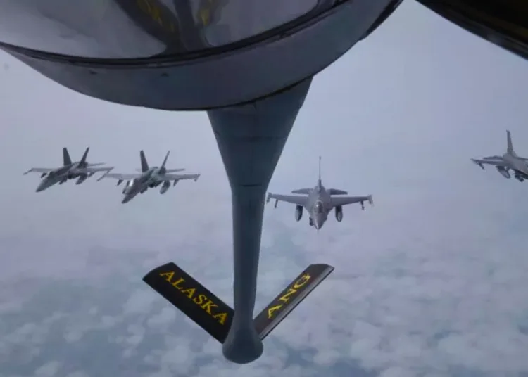Aviones de combate CF-18 del Mando de Defensa Aeroespacial de América del Norte, a la izquierda, y aviones de combate F-16, a la derecha, volando en formación cerca de Little Diomede Island, Alaska, el 10 de julio.DEPARTAMENTO DE DEFENSA DE EE.UU.