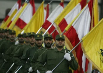 Combatientes de Hezbolá, portando banderas nacionales y la bandera amarilla del grupo chiita libanés, desfilan con motivo del Día del Mártir en los suburbios del sur de Beirut, el 11 de noviembre de 2009. Créditos: Ramzi Haidar/AFP.