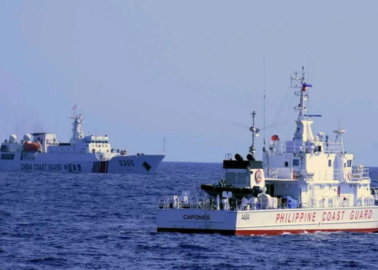 En esta foto facilitada por la Guardia Costera filipina, un buque de la Guardia Costera china navega cerca de un buque de la Guardia Costera filipina durante su patrulla en Bajo de Masinloc, a 124 millas náuticas al