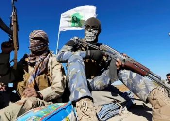 Combatientes chiíes enmascarados respaldados por Irán sostienen sus armas en la localidad iraquí de Al Hadidiya, al sur de Tikrit, de camino a la ciudad de Al Alam, controlada por el Estado Islámico, donde se preparan para lanzar una ofensiva el 6 de marzo de 2015. (Reuters/Thaier Al-Sudani)