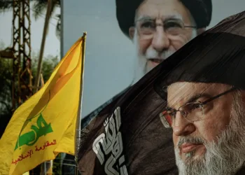 Una bandera con la imagen del líder proiraní de Hezbolá, Hassan Nasrallah, asesinado, ondea frente a una foto del líder supremo iraní, Ali Khamenei, durante una ceremonia que conmemora el primer aniversario del asesinato de Nasrallah en un ataque aéreo israelí, en su tumba en Beirut. Beirut, Líbano, 27 de septiembre de 2025. (