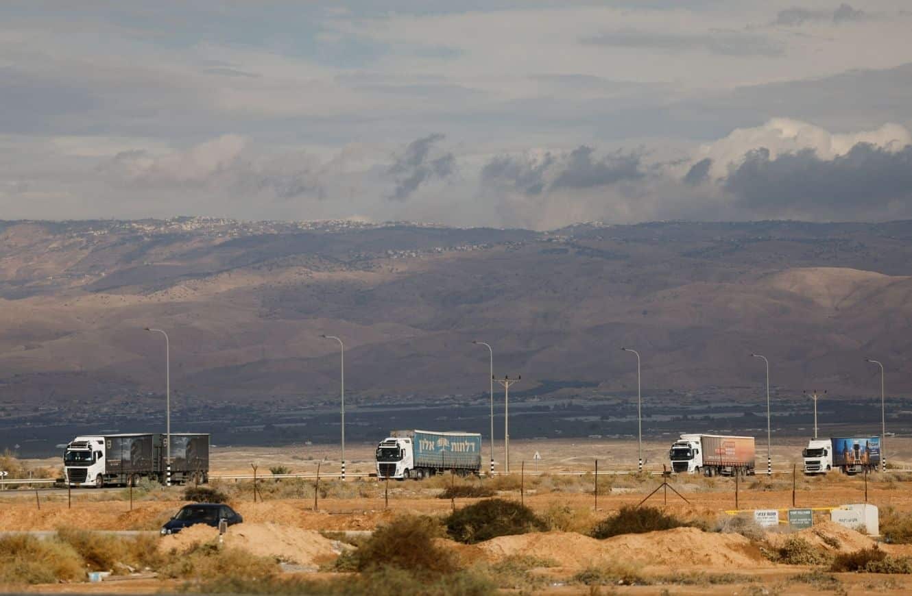 Camiones que transportan mercancías desde Jordania se mueven cerca del Cruce del Puente Allenby entre Cisjordania y Jordania después de su reapertura, en la Cisjordania ocupada por Israel, el miércoles. (Ammar Awad/Reuters)