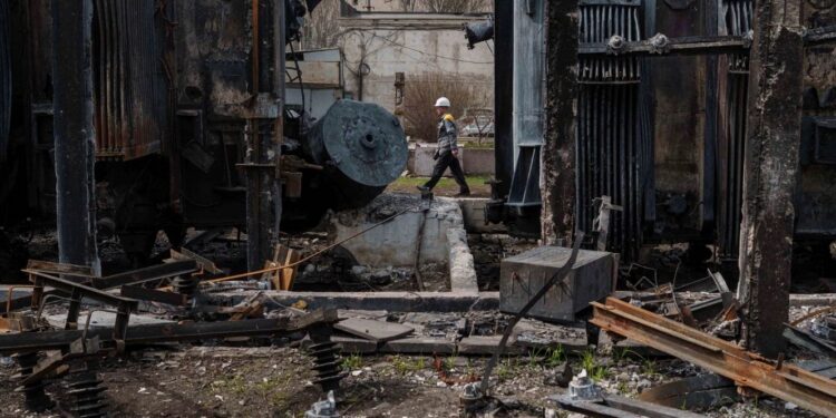 Un trabajador pasa junto a una subestación ucraniana destruida por un ataque con drones rusos. Fotografía: Evgeniy Maloletka/AP