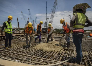 Varios obreros trabajan bajo órdenes de un capataz asiático en la ampliación del puerto de Tanga para poder atender a los futuros barcos petroleros que vendrán a cargar crudo para exportarlo, el pasado 14 de septiembre. Pablo Garrigós Cucarella