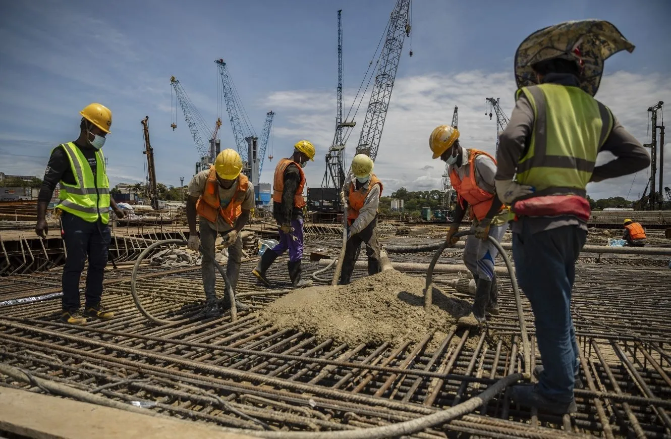 Varios obreros trabajan bajo órdenes de un capataz asiático en la ampliación del puerto de Tanga para poder atender a los futuros barcos petroleros que vendrán a cargar crudo para exportarlo, el pasado 14 de septiembre. Pablo Garrigós Cucarella