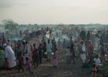 Las personas recién llegadas que huyen del conflicto en Sudán se reúnen en el paso fronterizo de Joda, en Sudán del Sur, a la espera de ser transportadas al centro de tránsito de Renk. Crédito: ACNUR/Ala Kheir