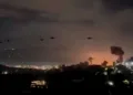 Helicópteros vuelan cerca de columnas de humo que se elevan tras explosiones, en Caracas, Venezuela, el 3 de enero de 2026, en esta captura de pantalla obtenida de un video proporcionado por Reuters. Video proporcionado por Reuters/vía REUTERS