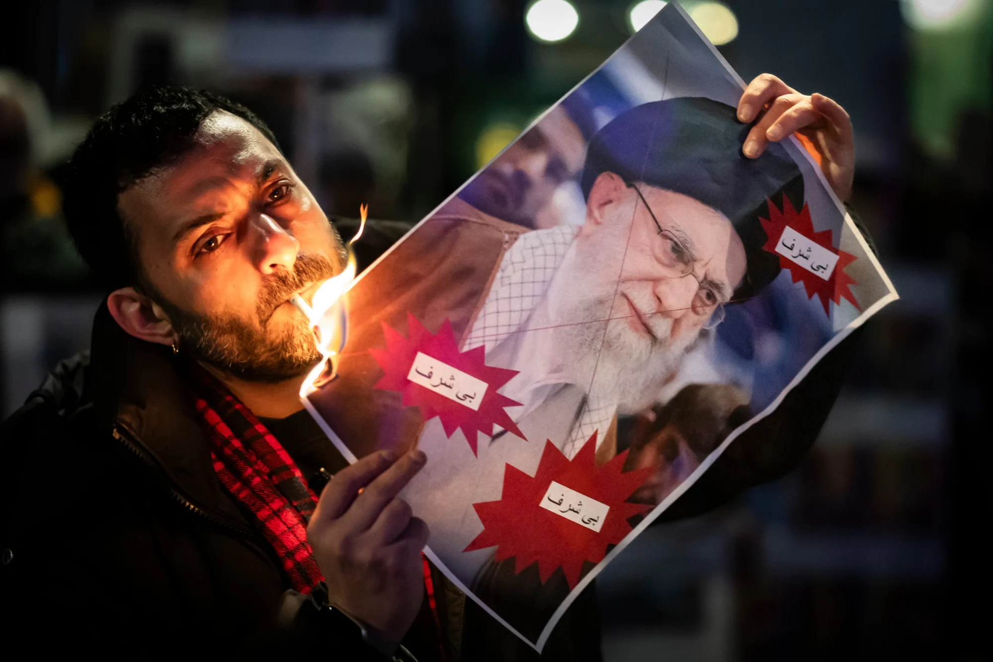 Un manifestante quema una imagen del Ayatolá Ali Khamenei con un cigarrillo durante una manifestación en apoyo a las protestas masivas a nivel nacional en Irán contra el gobierno, el martes 13 de enero de 2026 en Zúrich, Suiza. (Michael Buholzer / Keystone vía AP)