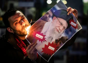 Un manifestante quema una imagen del Ayatolá Ali Khamenei con un cigarrillo durante una manifestación en apoyo a las protestas masivas a nivel nacional en Irán contra el gobierno, el martes 13 de enero de 2026 en Zúrich, Suiza. (Michael Buholzer / Keystone vía AP)
