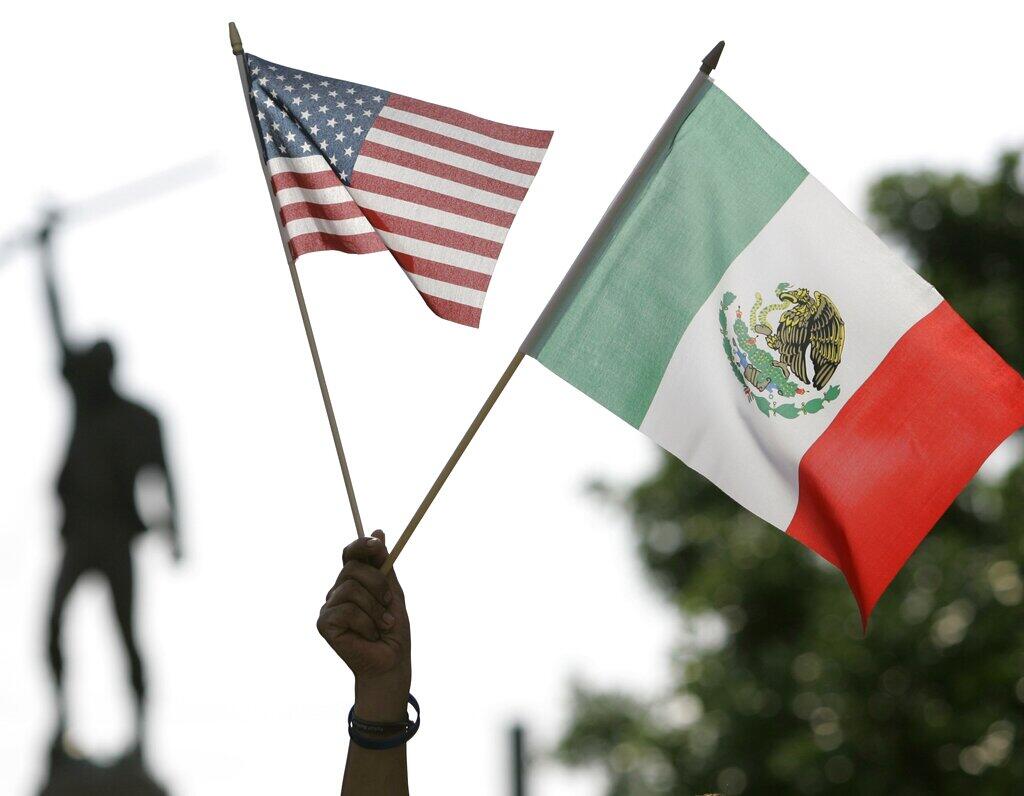 Un manifestante sostiene las banderas de Estados Unidos y México durante una manifestación para protestar contra las políticas de inmigración en San Antonio, el martes 1 de mayo de 2007. (Foto AP/Eric Gay)