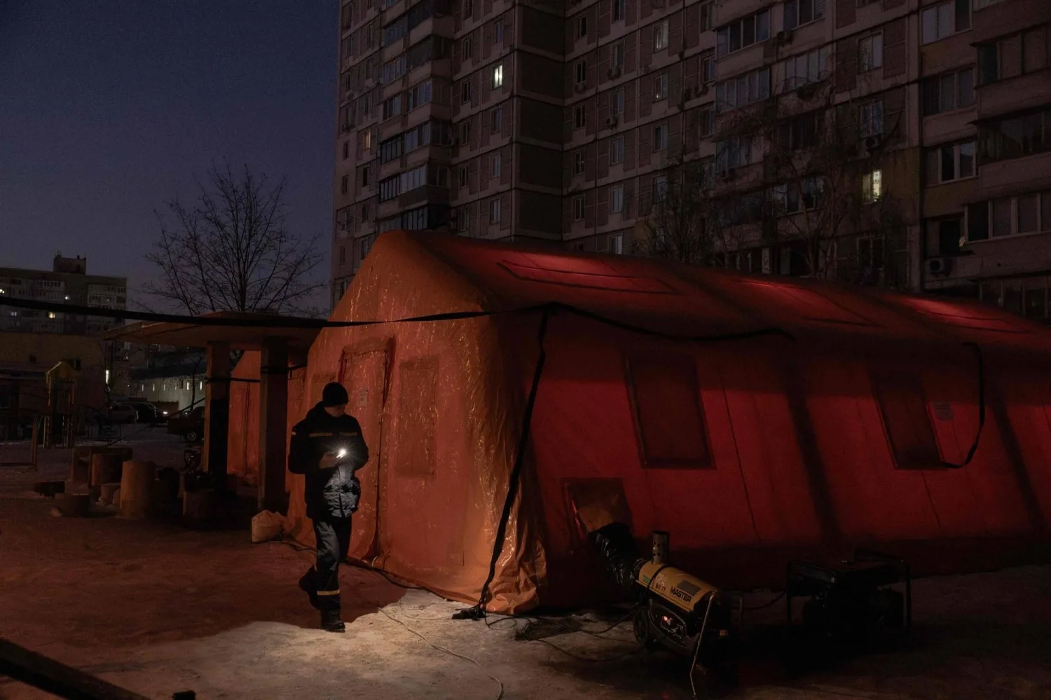 Un trabajador del servicio de emergencias de Ucrania camina junto a una carpa de servicio de emergencia instalada para aquellos cuyas casas están sin electricidad o calefacción en un barrio residencial de Kiev, el 20 de enero de 2026, tras los ataques con misiles y drones rusos contra la infraestructura energética ucraniana en medio de la invasión rusa en Ucrania. Un bombardeo nocturno ruso sobre Kiev dejó miles de edificios residenciales y el parlamento sin calefacción ni agua a -14 °C el martes, justo cuando la capital ucraniana se apresuraba a restaurar los servicios vitales destruidos en ataques anteriores. 