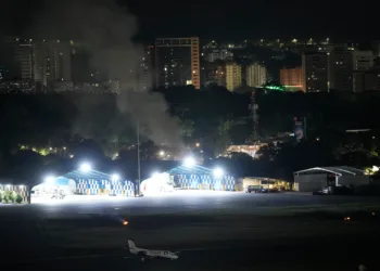 El humo se eleva en el aeropuerto de La Carlota después de que se escucharan explosiones y aviones volando a baja altura en Caracas, Venezuela, el sábado 3 de enero de 2026. (Foto AP/Matias Delacroix)
