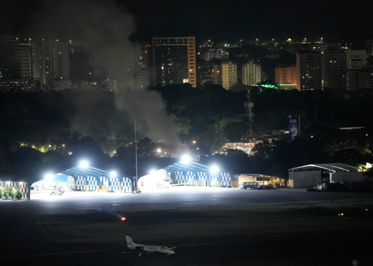 El humo se eleva en el aeropuerto de La Carlota después de que se escucharan explosiones y aviones volando a baja altura en Caracas, Venezuela, el sábado 3 de enero de 2026. (Foto AP/Matias Delacroix)