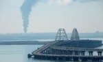Una densa columna de humo se eleva desde un depósito de combustible ruso en llamas cerca del Puente de Crimea, una ruta clave que conecta Rusia con Crimea y que Moscú utiliza para transportar tropas y equipo al frente en Ucrania. Créditos: REUTERS/Stringer.