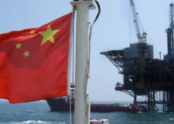 Bandera china con refinería de fondo