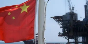Bandera china con refinería de fondo