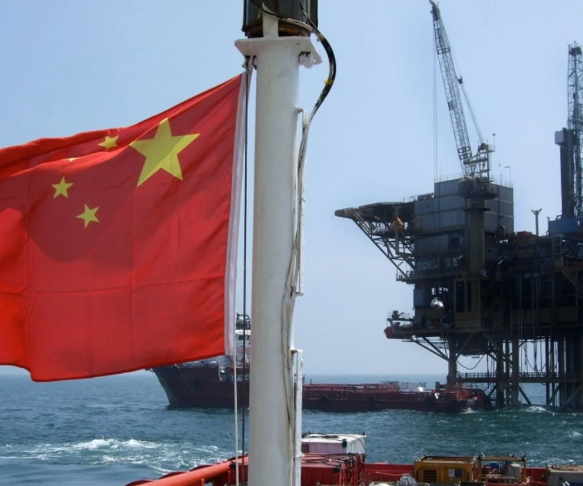 Bandera china con refinería de fondo