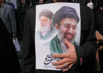 Mujer sostiene una imagen del ex líder supremo Alí Jamenei y el actual Mojtaba Jamenei en una manifestación en Teherán posterior a su nombramiento. Crédito: AP Photo