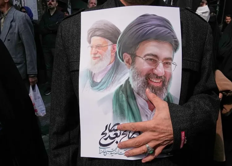 Mujer sostiene una imagen del ex líder supremo Alí Jamenei y el actual Mojtaba Jamenei en una manifestación en Teherán posterior a su nombramiento. Crédito: AP Photo