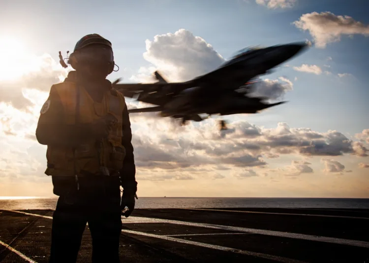 Un marinero de la Marina de los EE. UU. actúa como oficial de equipo de detención mientras un avión F/A-18F Super Hornet, asignado al Escuadrón de Cazas de Ataque 213, aterriza en la cubierta de vuelo del portaaviones más grande del mundo, el USS Gerald R. Ford (CVN 78), durante operaciones en apoyo de la Operación Epic Fury en el mar Mediterráneo oriental, el 2 de marzo de 2026. (Foto de la Marina de los EE. UU.)
