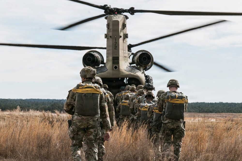 Paracaidistas estadounidenses asignados al 1.er Equipo de Combate de Brigada, 82.ª División Aerotransportada, llevan a cabo una operación aerotransportada desde un CH-47 Chinook en la Zona de Lanzamiento Sicily, Fort Bragg, Carolina del Norte, el 12 de febrero de 2026. (Foto del Ejército de los EE. UU. por el Capitán Alvin Cade Jr.)