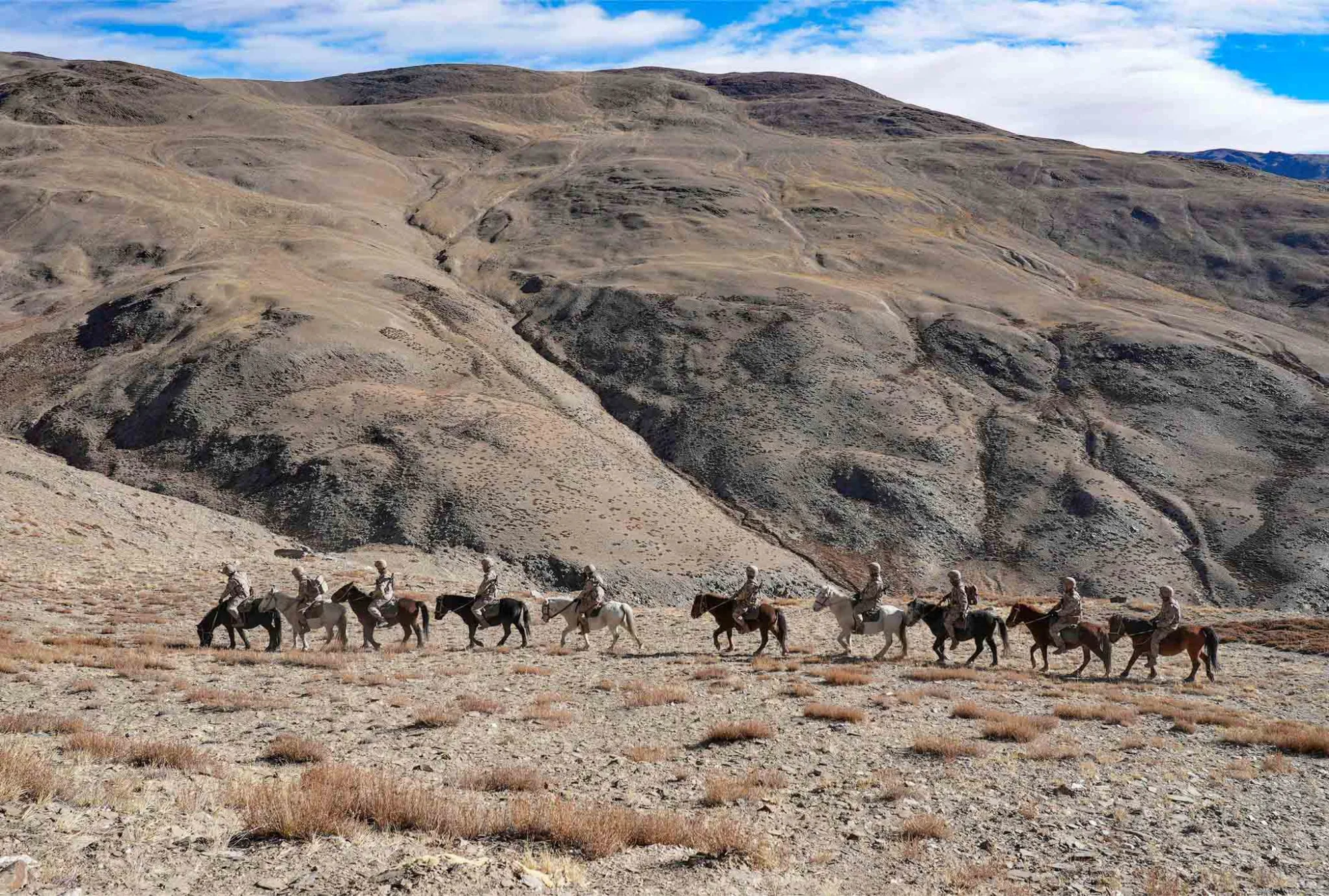 Las fotos muestran a soldados del Ejército Popular de Liberación (EPL) de China guiando a sus caballos durante una patrulla fronteriza en la cordillera del Karakórum, en la prefectura de Ali, situada en la Región Autónoma del Tíbet, al suroeste de China, a una altitud de más de 4.200 metros (7 de diciembre de 2024). Créditos: Cuenta oficial de prensa de las fuerzas armadas de China.