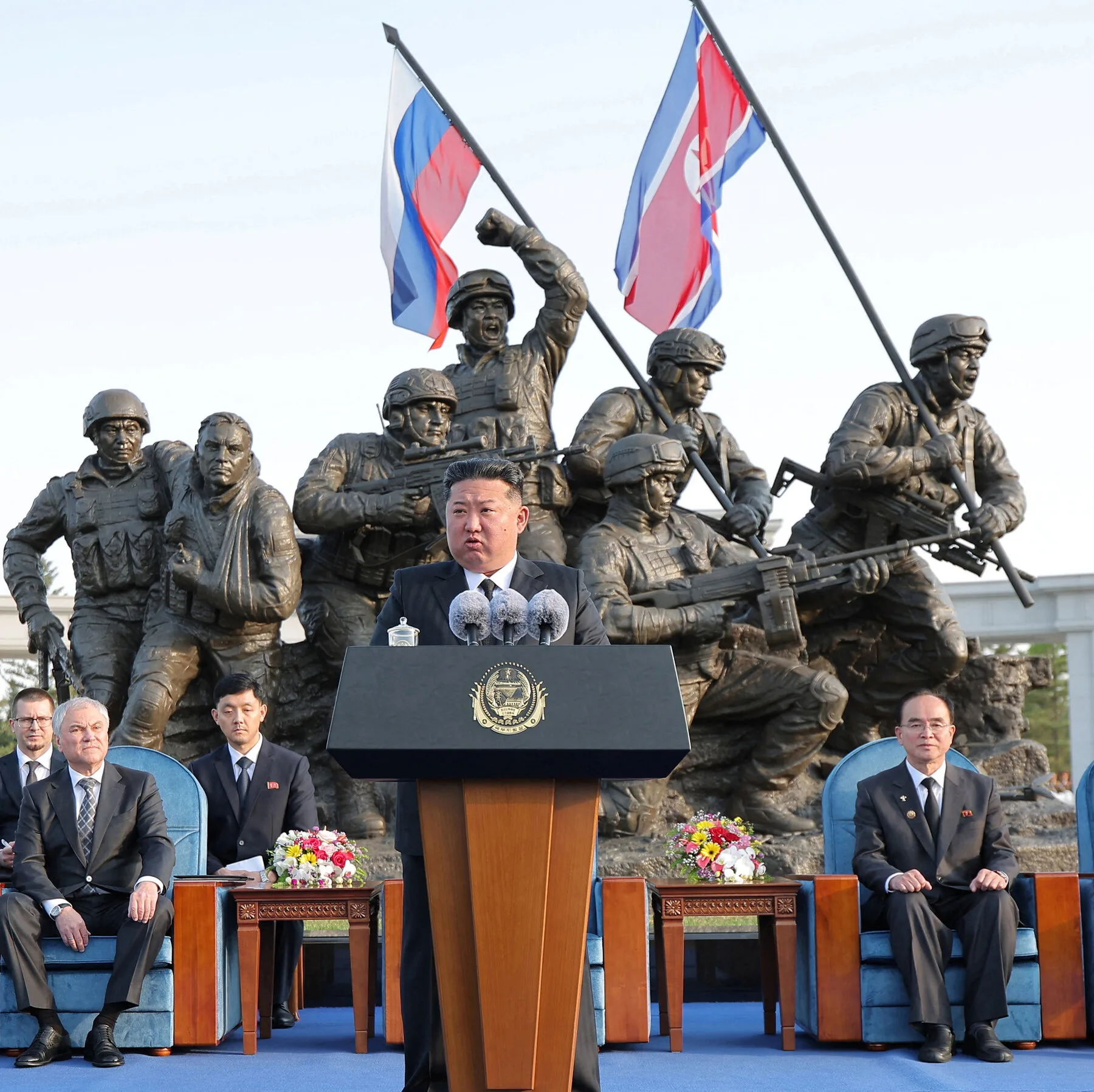 Kim Jong Un en la ceremonia frente a una escultura de soldados con banderas de Rusia y Corea del Norte, destacando el apoyo mutuo en el conflicto. Créditos: KCNA.