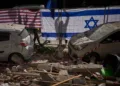 Las autoridades israelíes cuelgan banderas de Israel y Estados Unidos en el lugar impactado por un misil iraní que mató a dos personas, en Ramat Gan, Israel, el miércoles 18 de marzo de 2026. Oded Balilty / AP