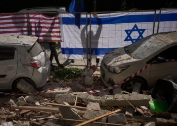 Las autoridades israelíes cuelgan banderas de Israel y Estados Unidos en el lugar impactado por un misil iraní que mató a dos personas, en Ramat Gan, Israel, el miércoles 18 de marzo de 2026. Oded Balilty / AP