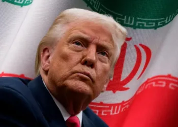 Trump con la bandera de Irán de fondo
