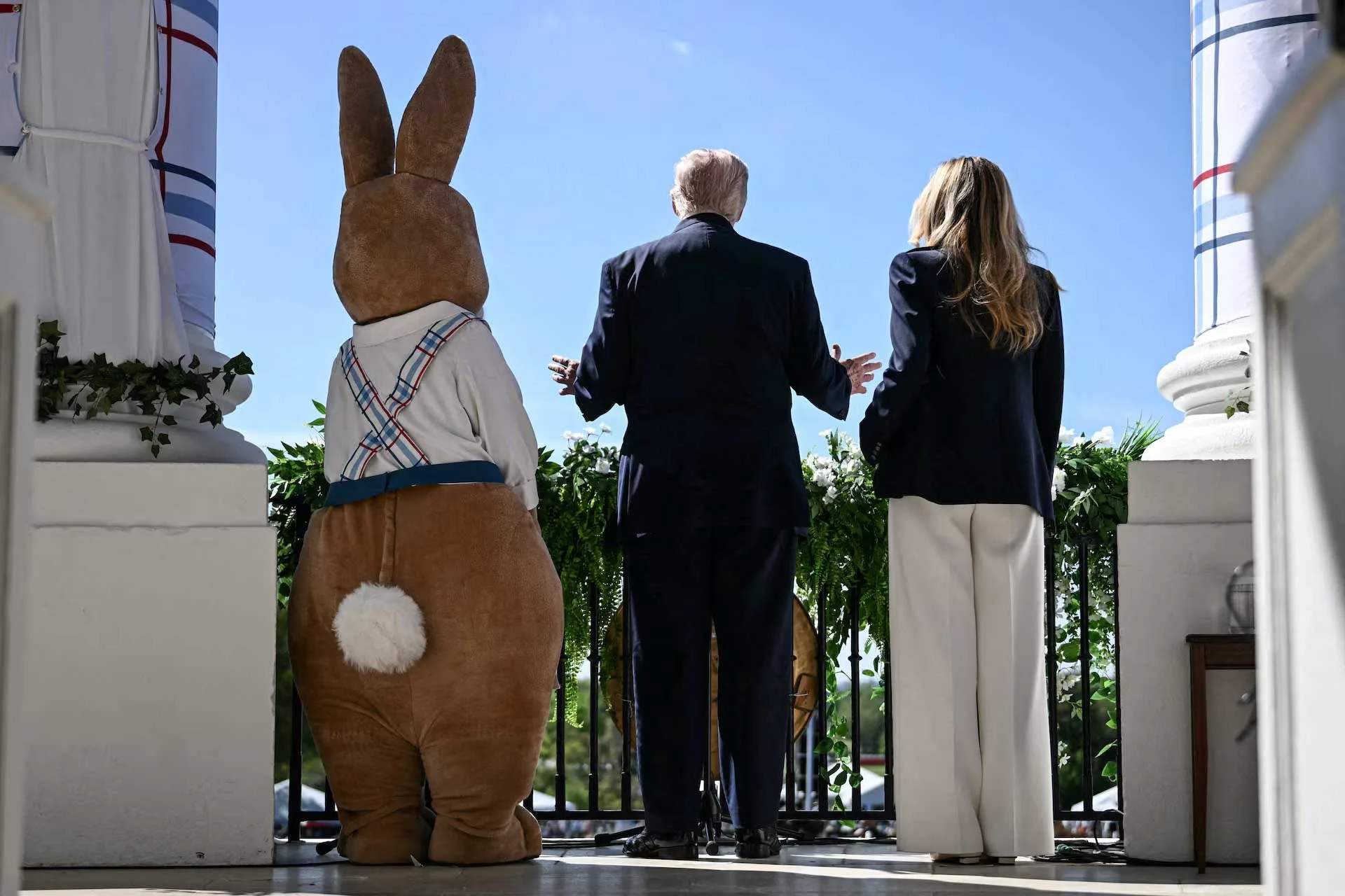 El presidente Donald Trump y la primera dama Melania Trump posan junto a un conejito de Pascua disfrazado mientras se dirigen a la multitud durante el evento anual «Easter Egg Roll» en el Jardín Sur de la Casa Blanca, en Washington D. C., el 6 de abril. Créditos: BRENDAN SMIALOWSKI/Pool vía REUTERS