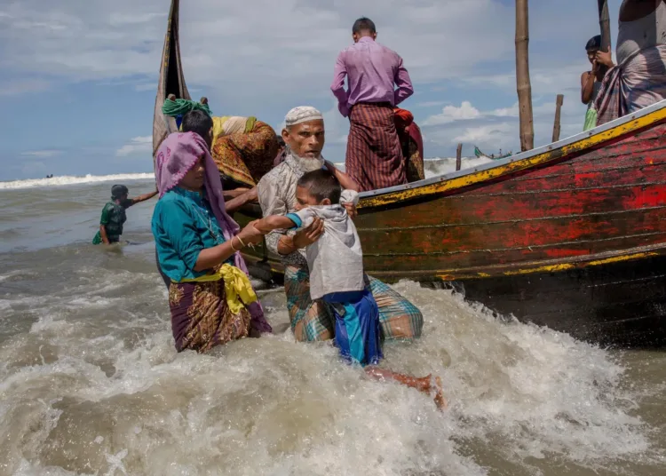 Un anciano musulmán rohingya ayuda a un niño a bajar de una embarcación tras llegar de Myanmar a Bangladés el 14 de septiembre. Créditos: Dar Yasin—AP