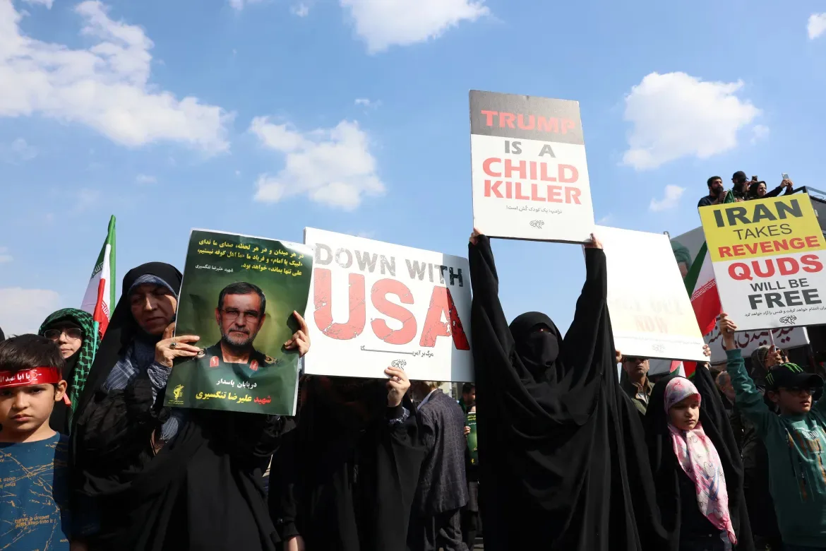 Una mujer sostiene un retrato de Alireza Tangsiri y carteles contra Estados Unidos durante su funeral. Créditos: AFP/ Aljazeera.