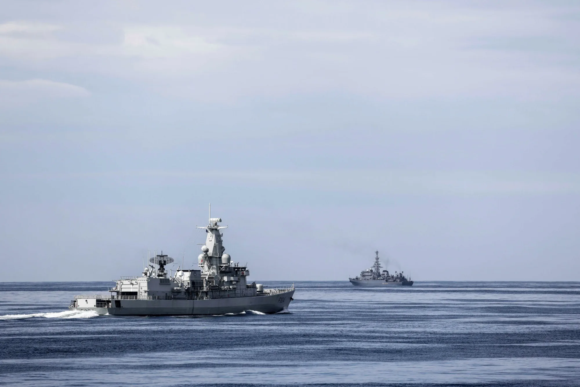 NATO Maritime Command muestra unidades de la SNMG1 vigilando al buque ruso de inteligencia Yuri Ivanov cerca del ejercicio Dynamic Mongoose 2026 en el Alto Norte, con imágenes de buques aliados, el navío ruso y un helicóptero Merlin. Créditos: NATO Maritime Command.