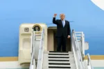 La imagen muestra a Trump en las escaleras del Air Force One con el puño en alto, capturando el momento de "wheels up" mientras regresa a Estados Unidos. Créditos: Casa Blanca.